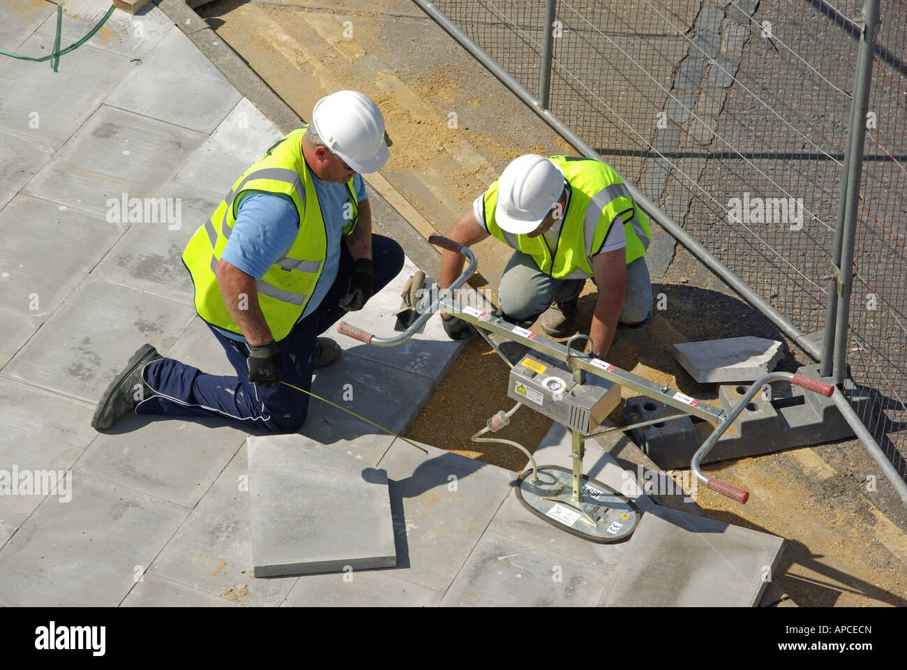 London pavement relaying work in progress two workmen kneeling beside