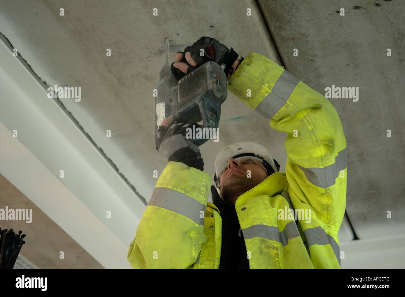 Construction worker drilling into concrete ceiling Stock Photo Alamy