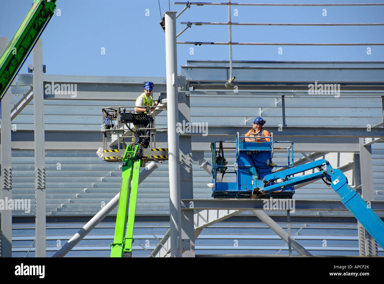 Steel erectors on cherry pickers access platforms during installation