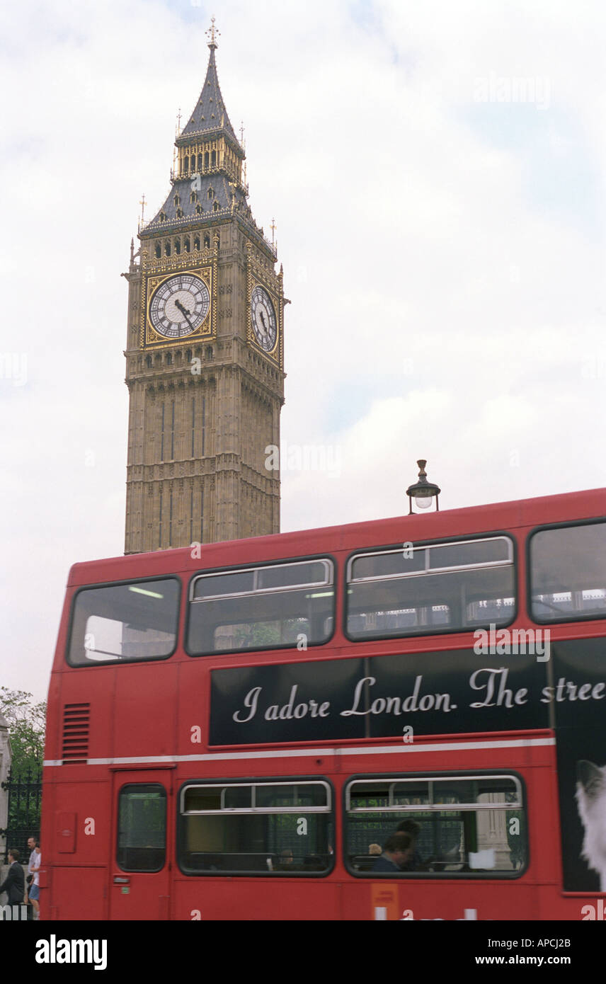 a red double decker bus passes in front of the Big Ben Clock Tower at the Houses of Parliament in Westminster London Stock Photo
