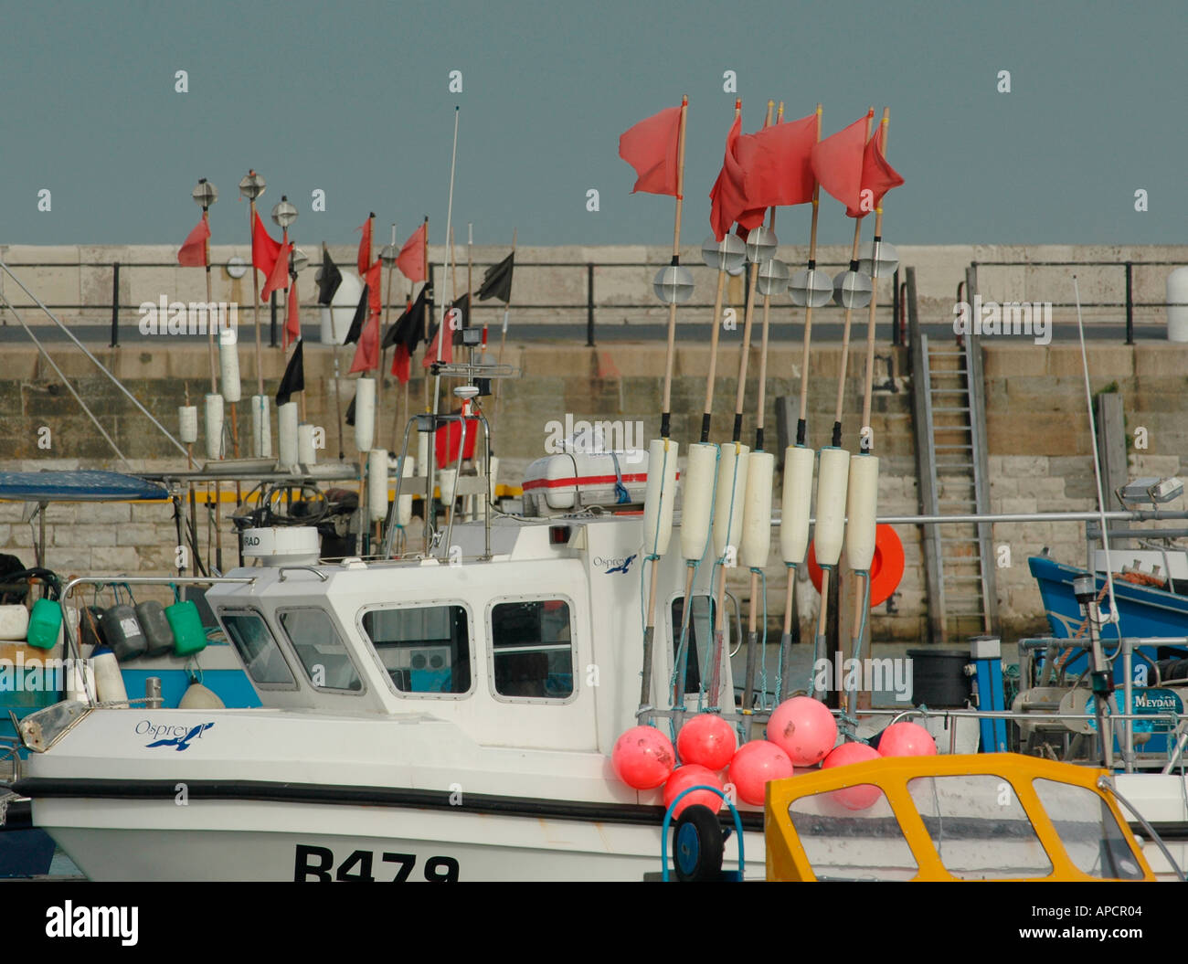 Fishing boat and equipment with buoys and red marker flags Stock Photo