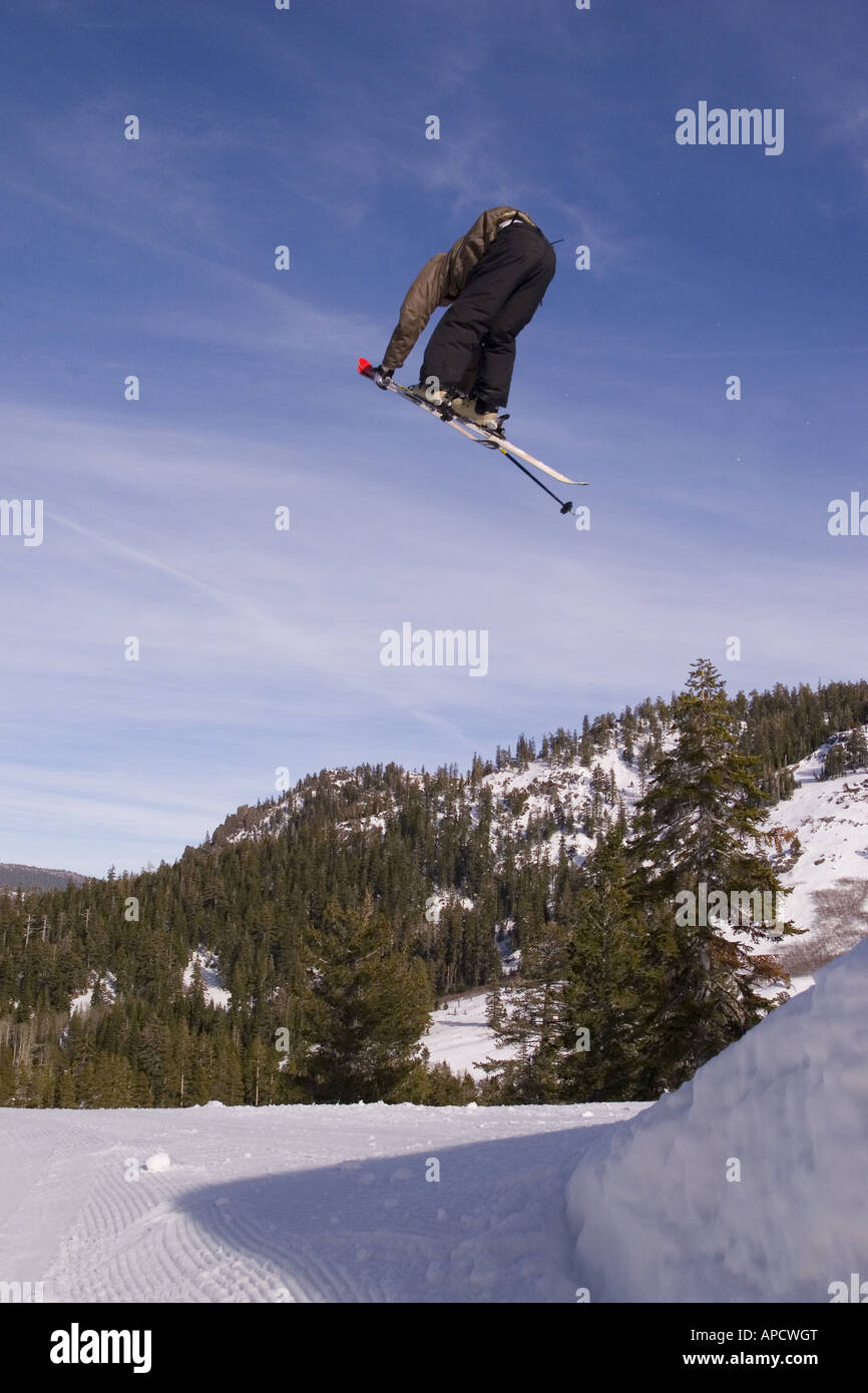A skier doing a trick off a jump in the terrain park at the Alpine Meadows ski area Stock Photo