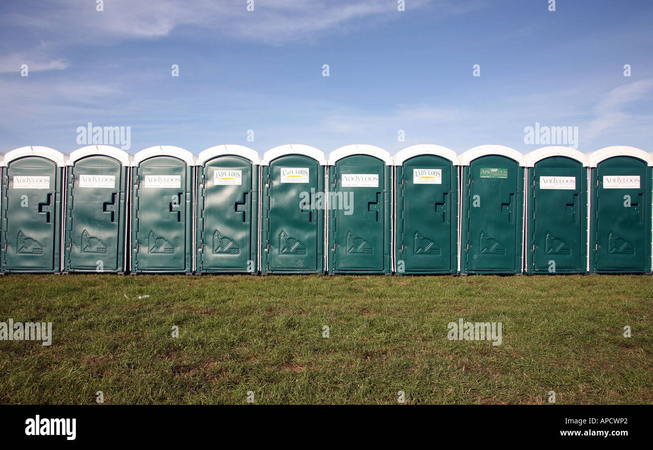 A row of green portable toilets in a field Stock Photo