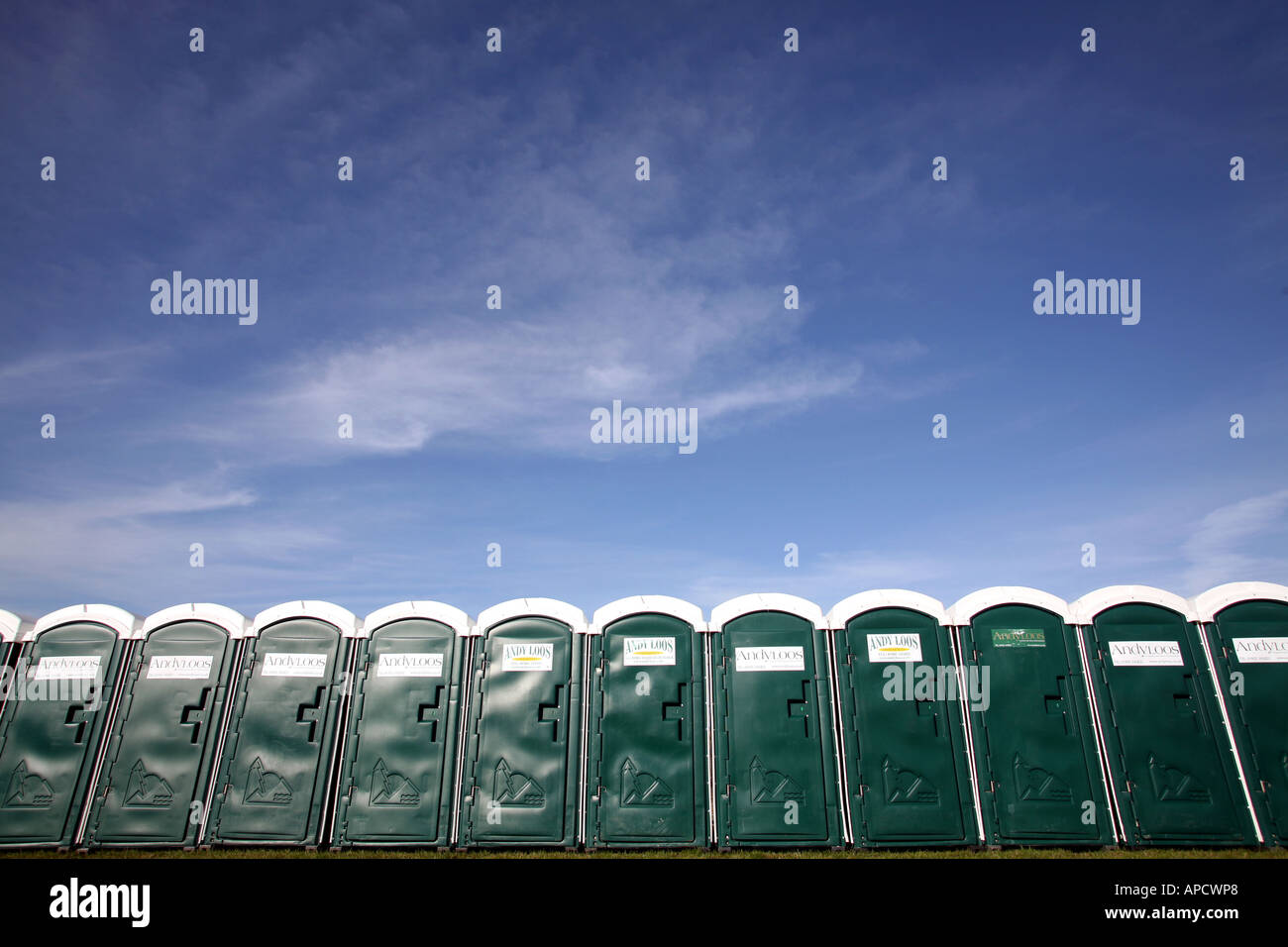 A row of green portable toilets Stock Photo
