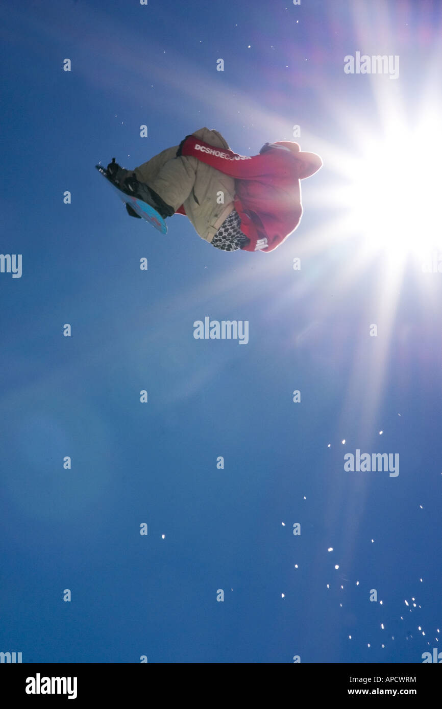 A snowboarder jumping off a jump with a sunburst at Alpine Meadows in California Stock Photo