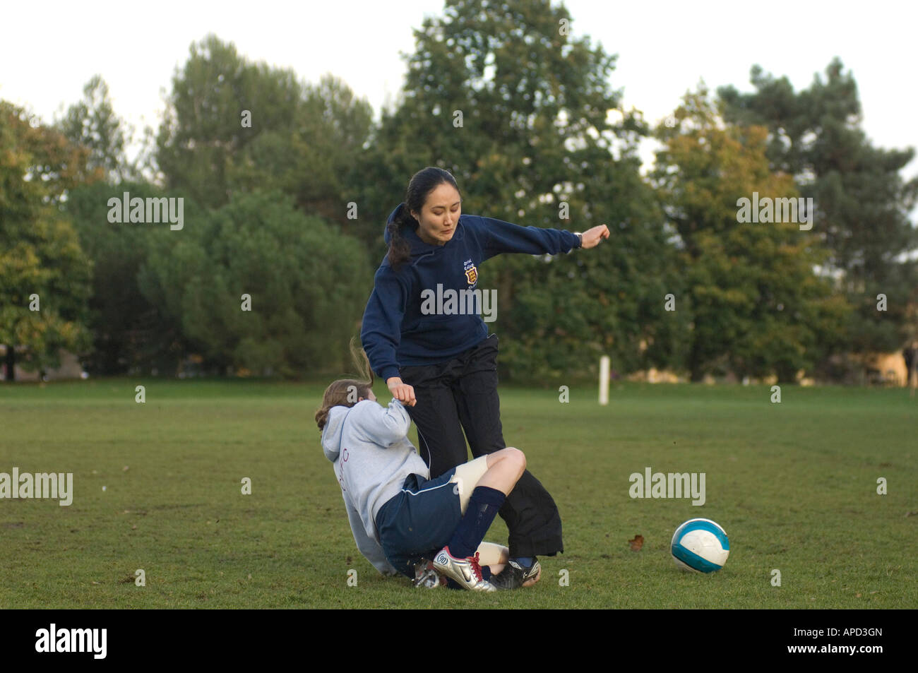 Girls football one of the fastest growing sports here a heavy tackle comes in to win the ball Stock Photo