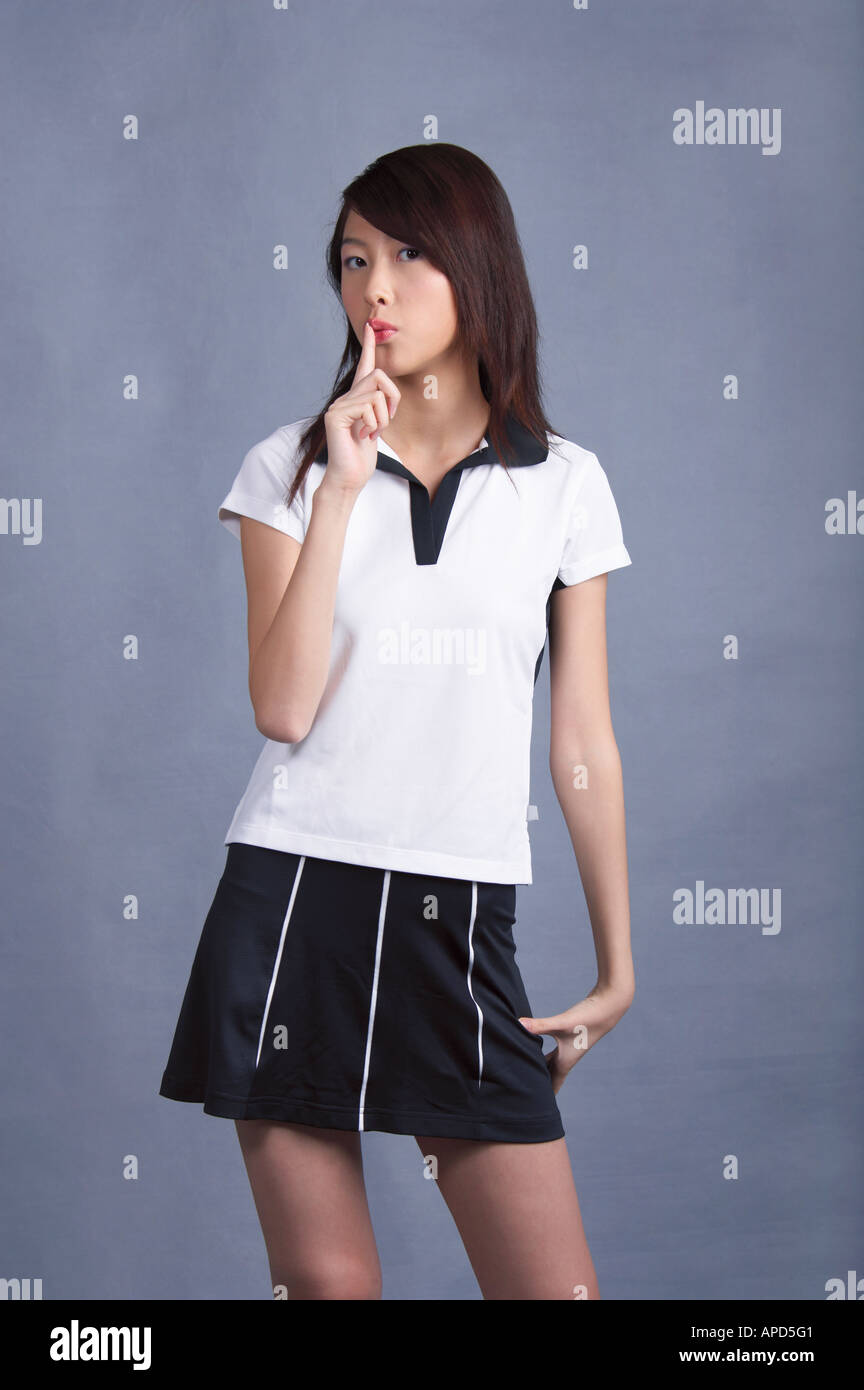 Young woman standing finger on lips Stock Photo - Alamy