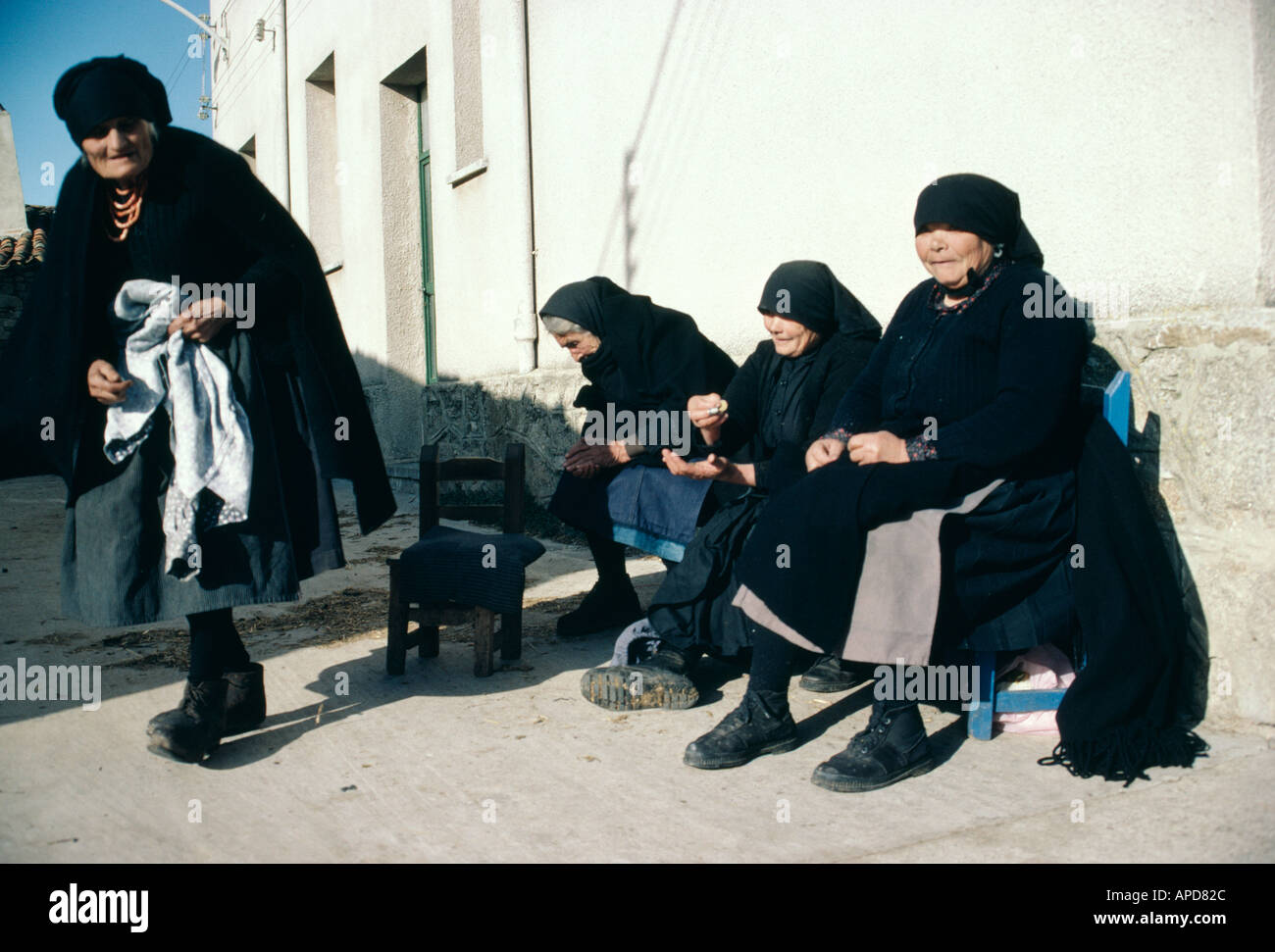 In a Spanish village women wearing stark black enjoy the afternoon sun Stock Photo