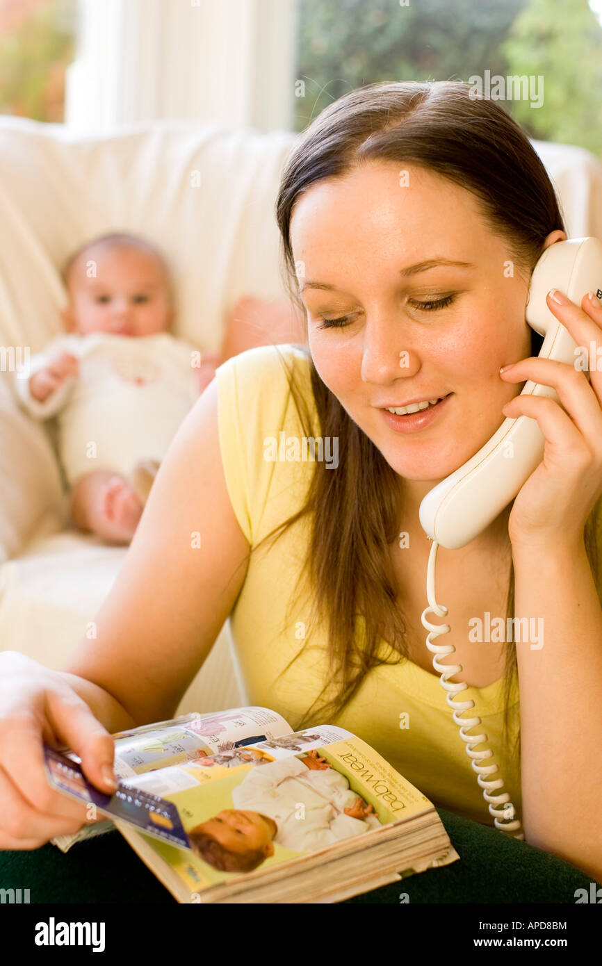 Woman ordering items from catalogue Stock Photo