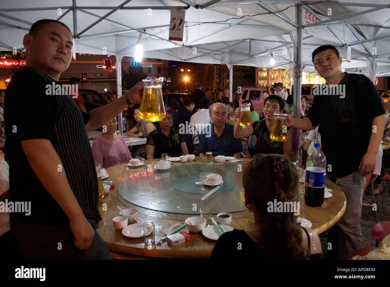 A family poses with their pitchers of beer at a restaurant near the Tsingtao brewery Qingdao Shandong China Stock Photo