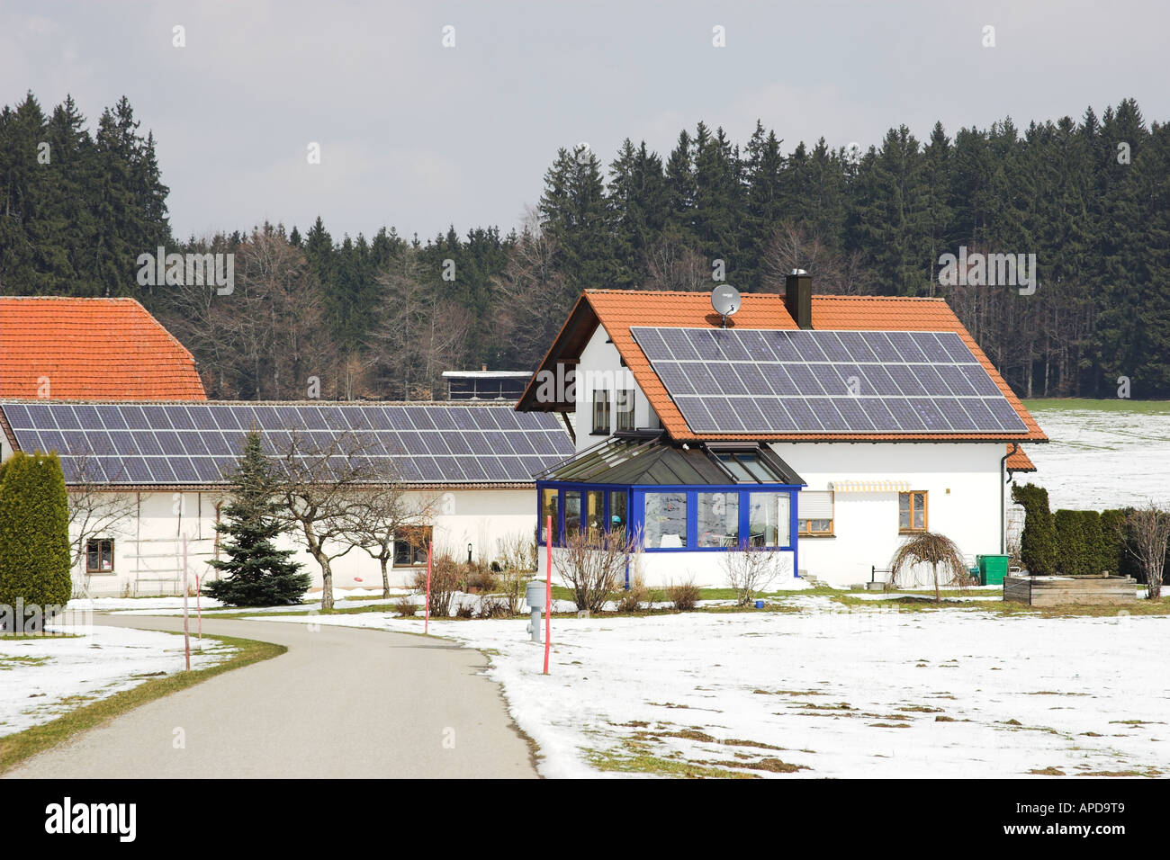Farm buildings roofs in Southeren Germany covered with PV (photovoltaic) cells for electricity generation for sale to the networ Stock Photo