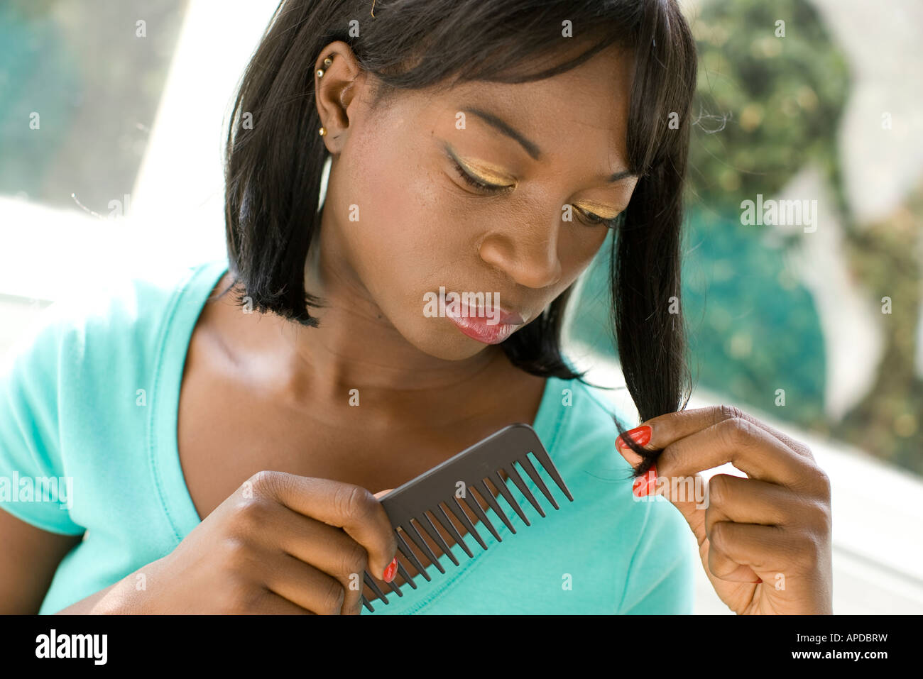 ethnic woman combing her hair Stock Photo