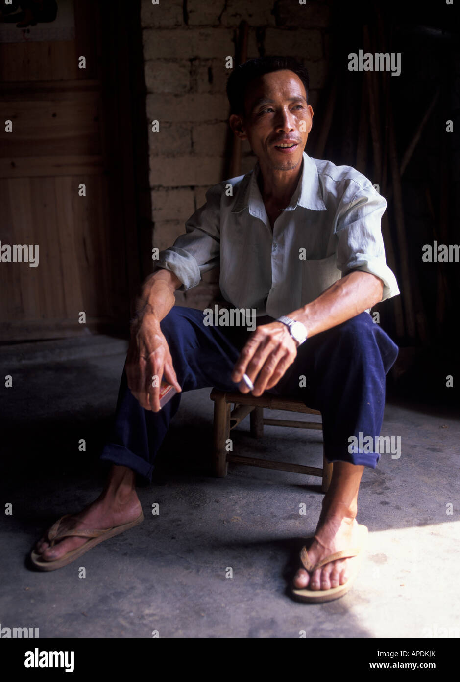 Chinese man having a cigarette break, Yangshuo, Guangxi Province, China Stock Photo