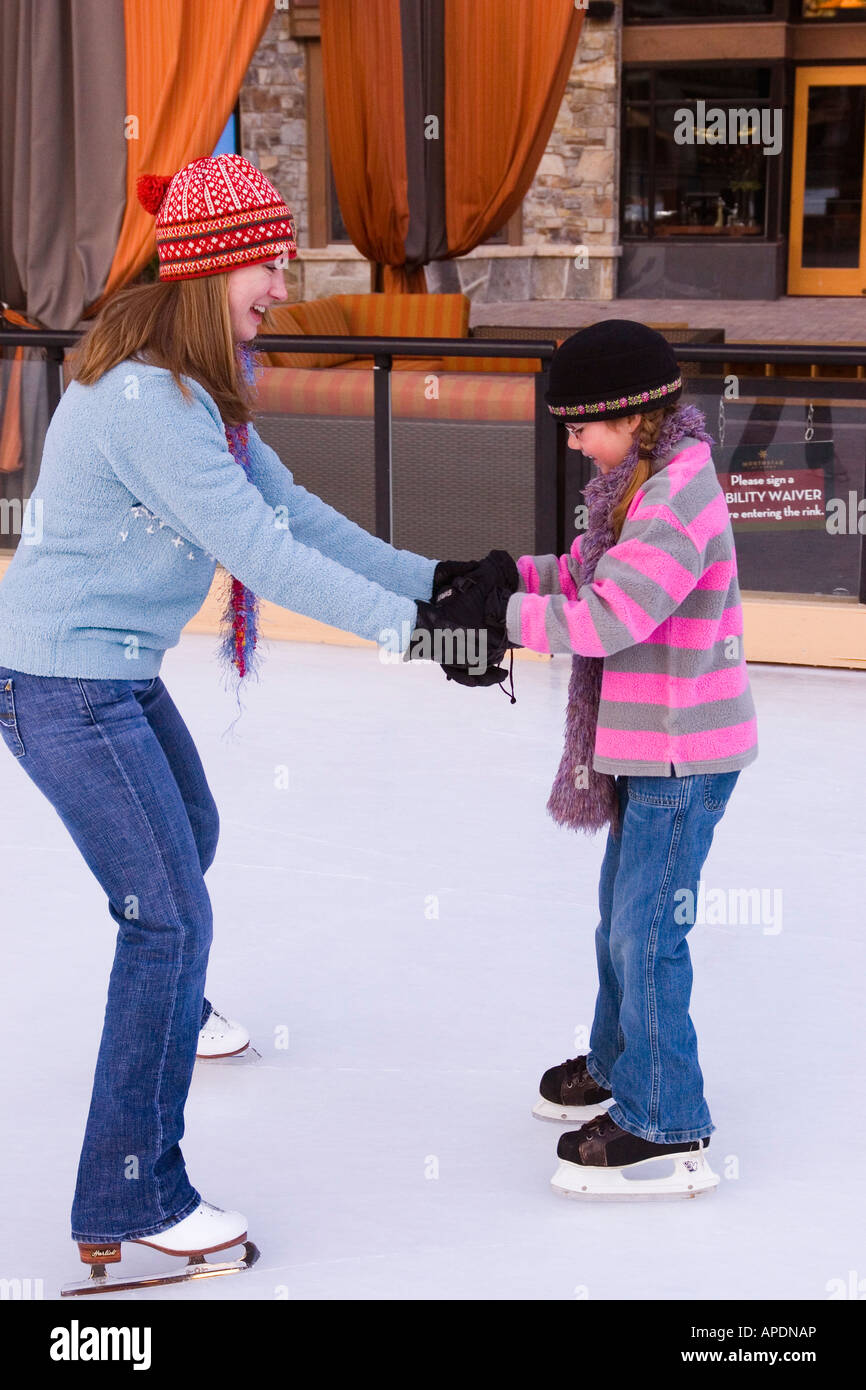 A mother helping her daughter while ice skating at Northstar ski resort near Lake Tahoe in California Stock Photo
