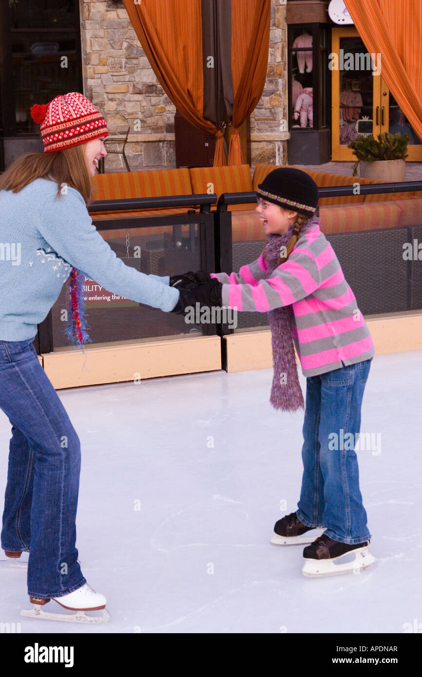 A mother helping her daughter while ice skating at Northstar ski resort near Lake Tahoe in California Stock Photo