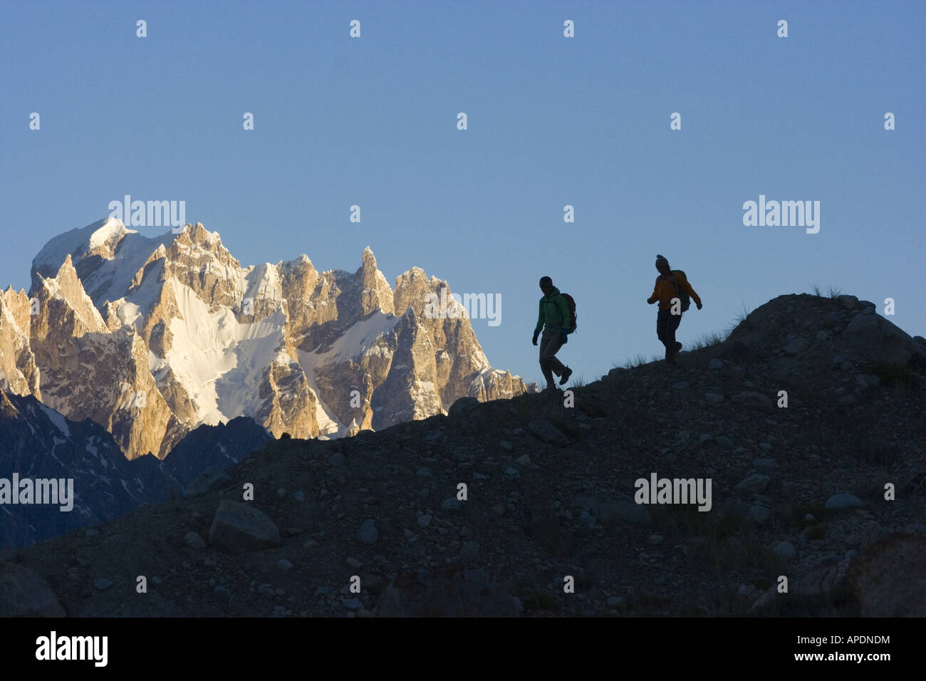 A silhouette of two women hikers on the Biafo glacier in the Karakoram Himalaya in Pakistan Stock Photo