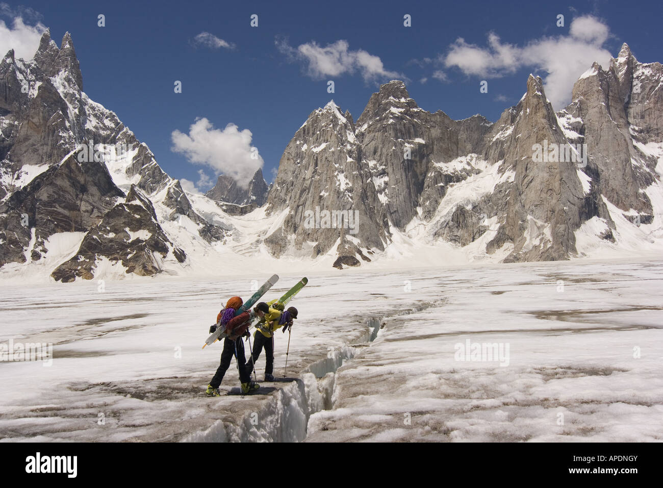 Two women ski mountaineers looking into a crevasse on the Biafo glacier in the Karakoram mountains of Pakistan Stock Photo