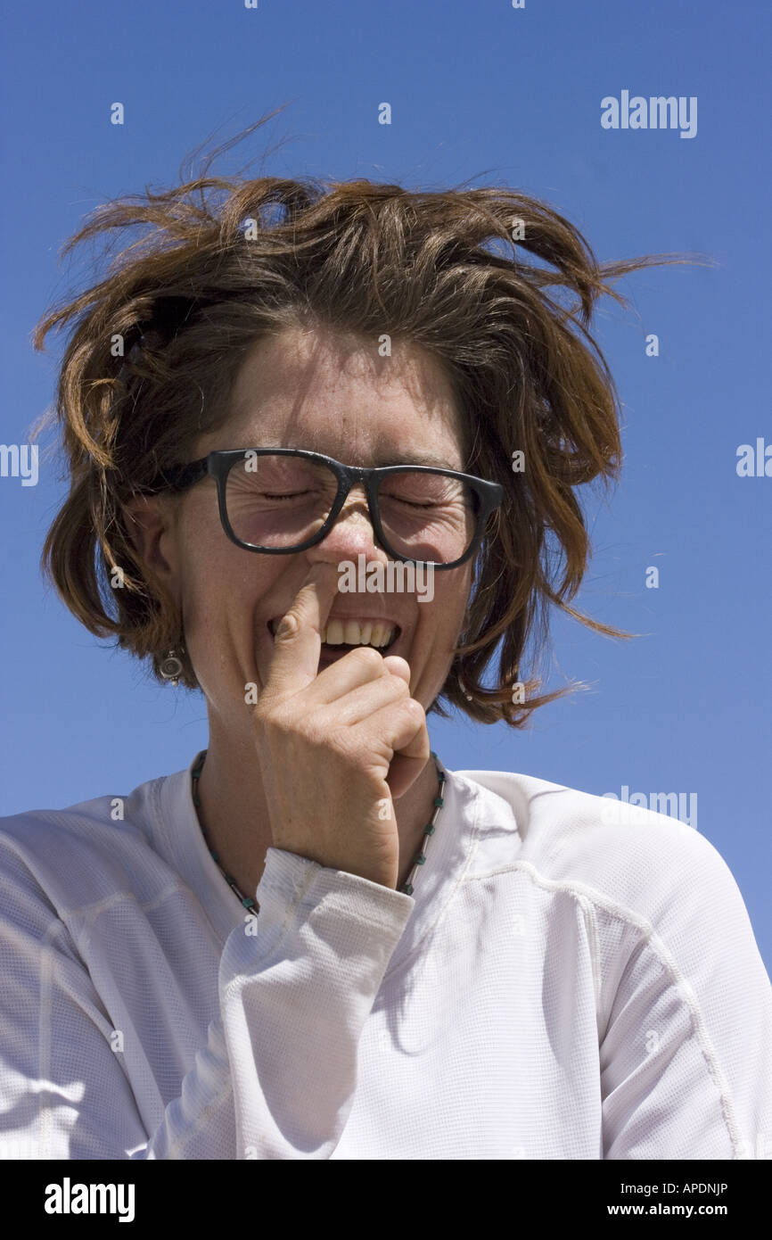 A woman picking and blowing her nose Stock Photo