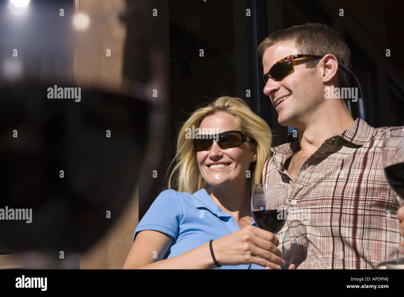 A happy couple smiling and drinking wine at Northstar ski resort near Lake Tahoe in California Stock Photo
