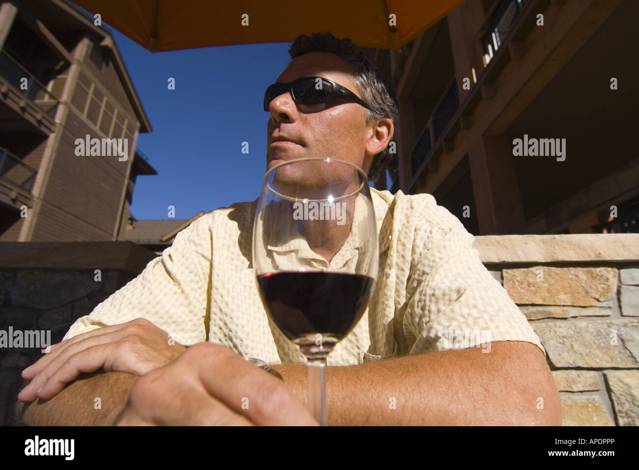 A man sitting at a table with a wine glass at Northstar ski resort near Lake Tahoe in California Stock Photo