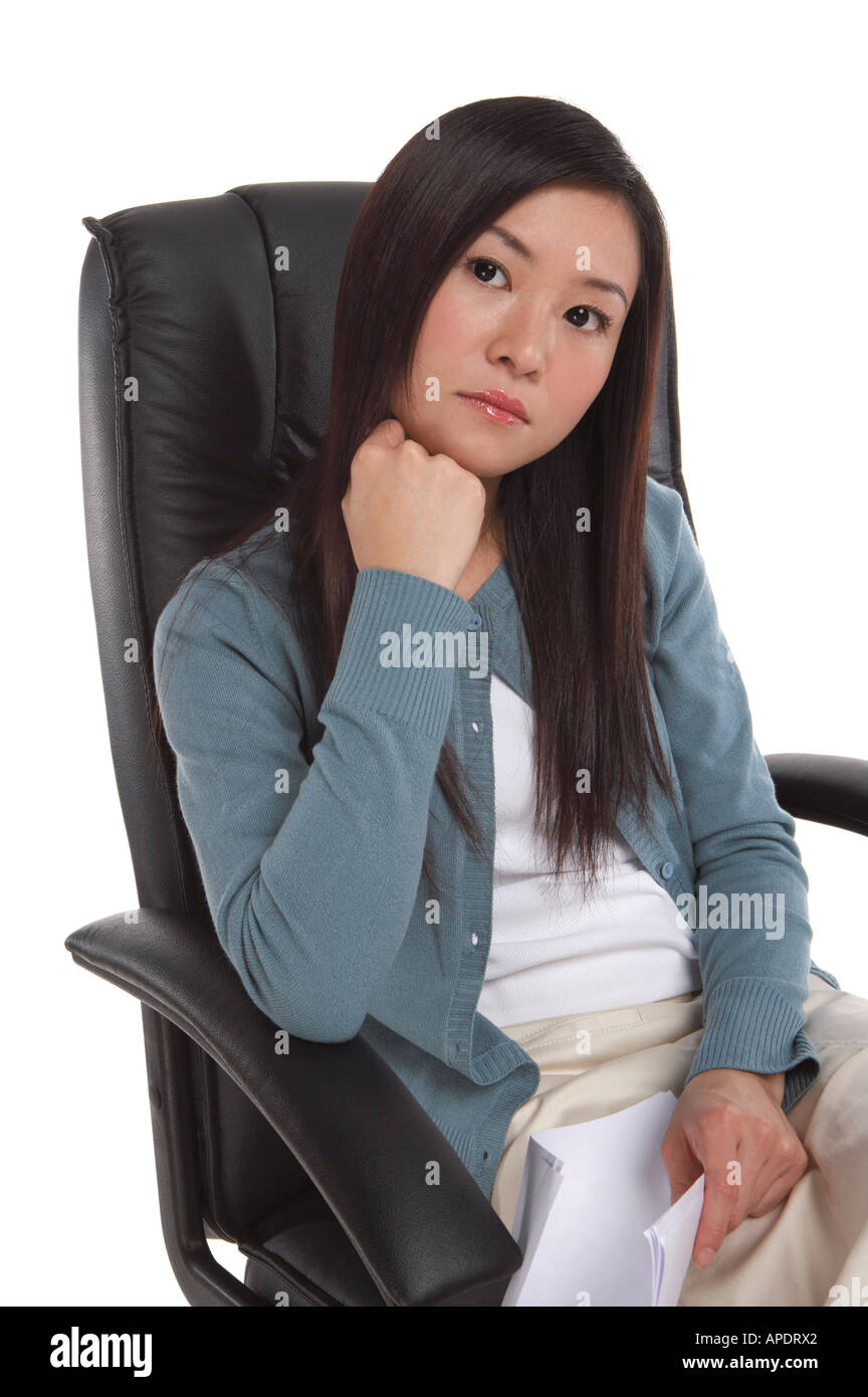 Young woman sitting on armchair thinking Stock Photo Alamy