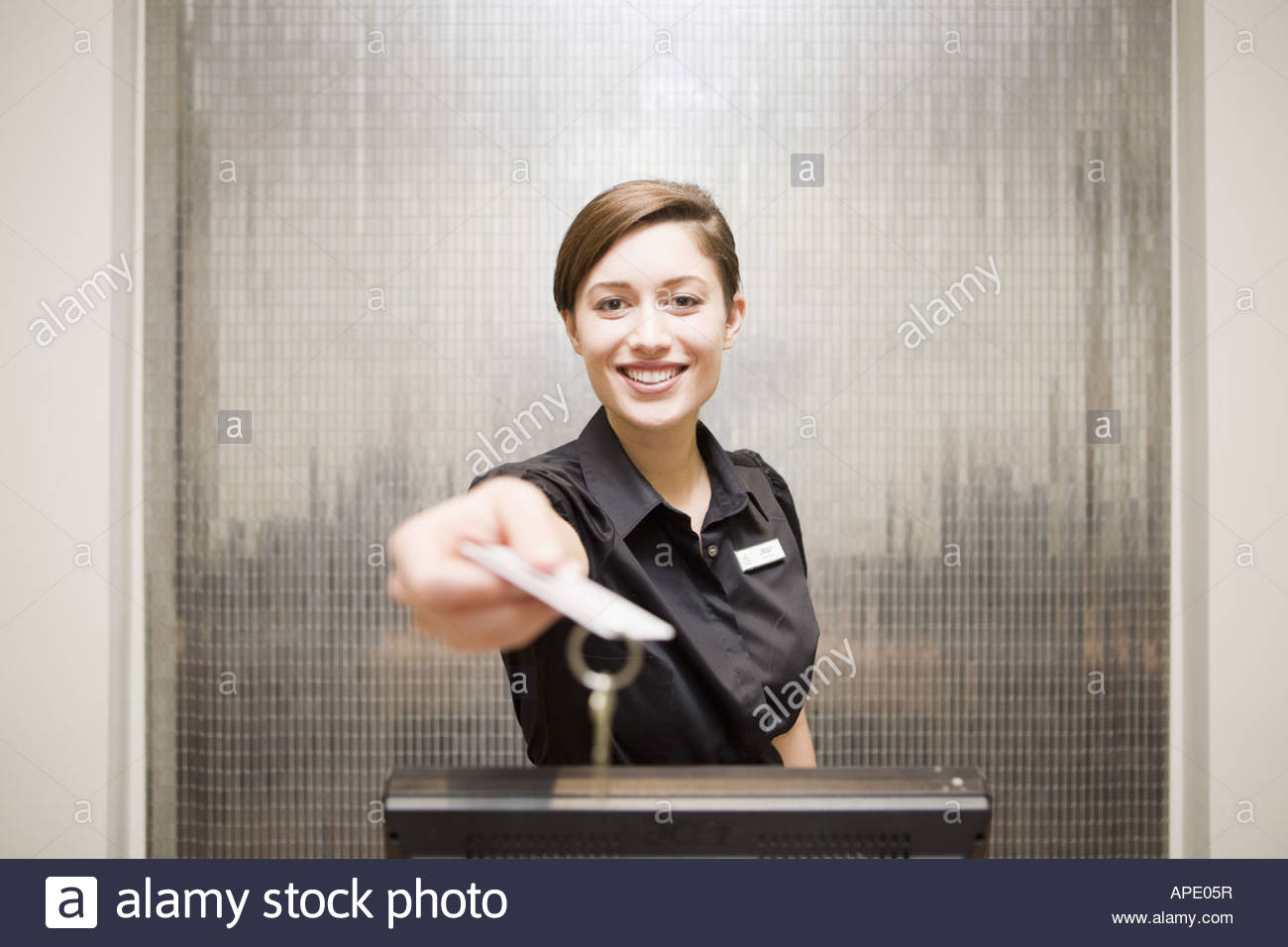 Female Hotel Front Desk Clerk Handing Keycard Stock Photo