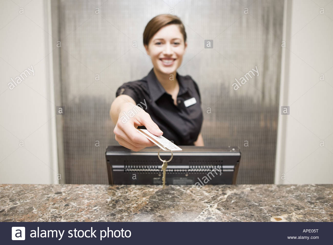 Female Hotel Front Desk Clerk Handing Keycard Stock Photo