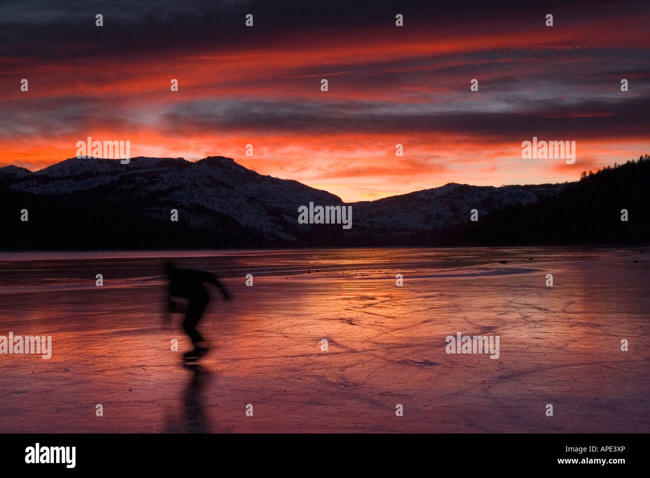 A blurry skater on frozen Donner Lake California at sunset Stock Photo
