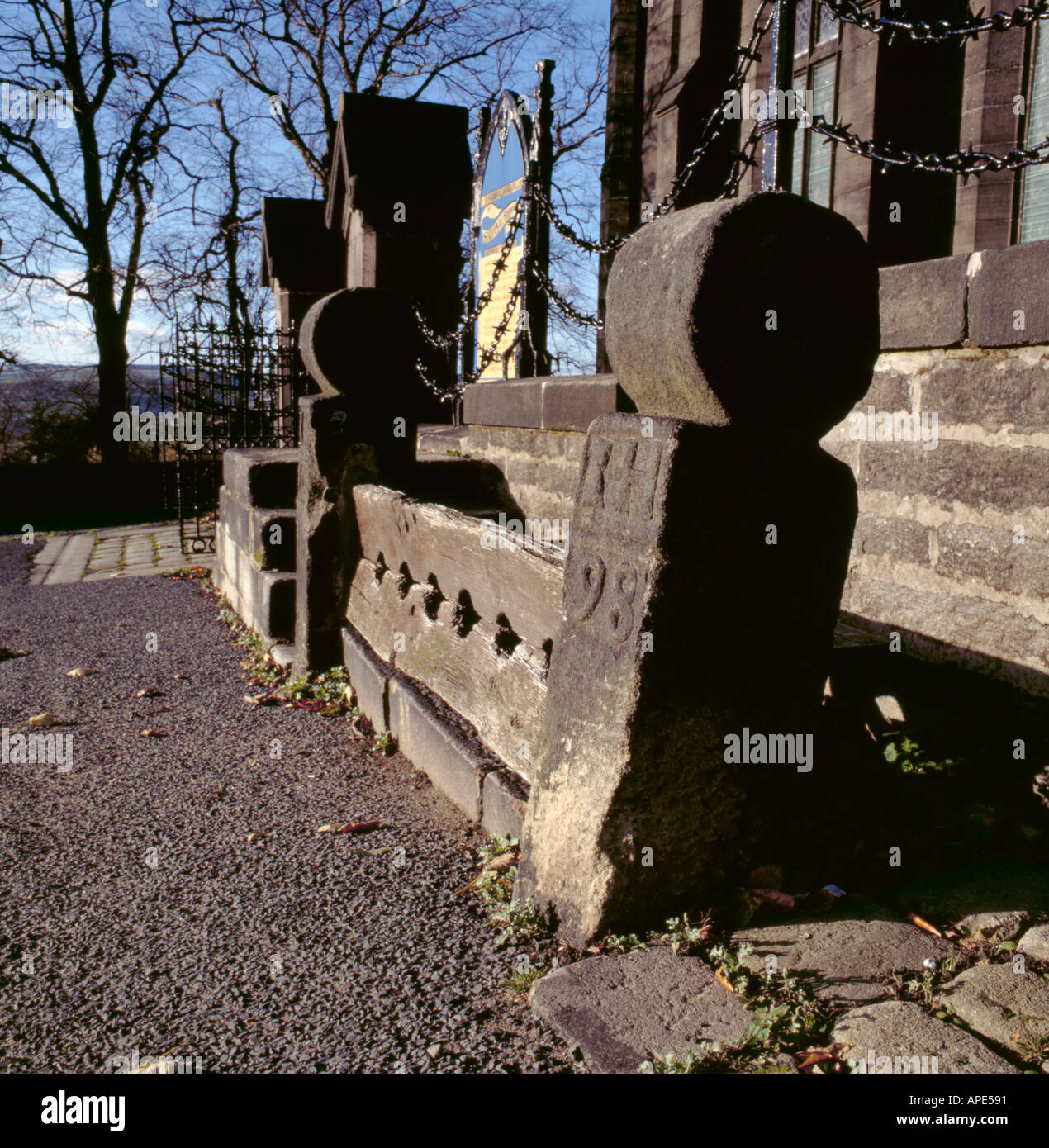 Old set of stocks outside a churchyard at Saddleworth Church, near Uppermill, near Oldham, Greater Manchester, England, UK. Stock Photo