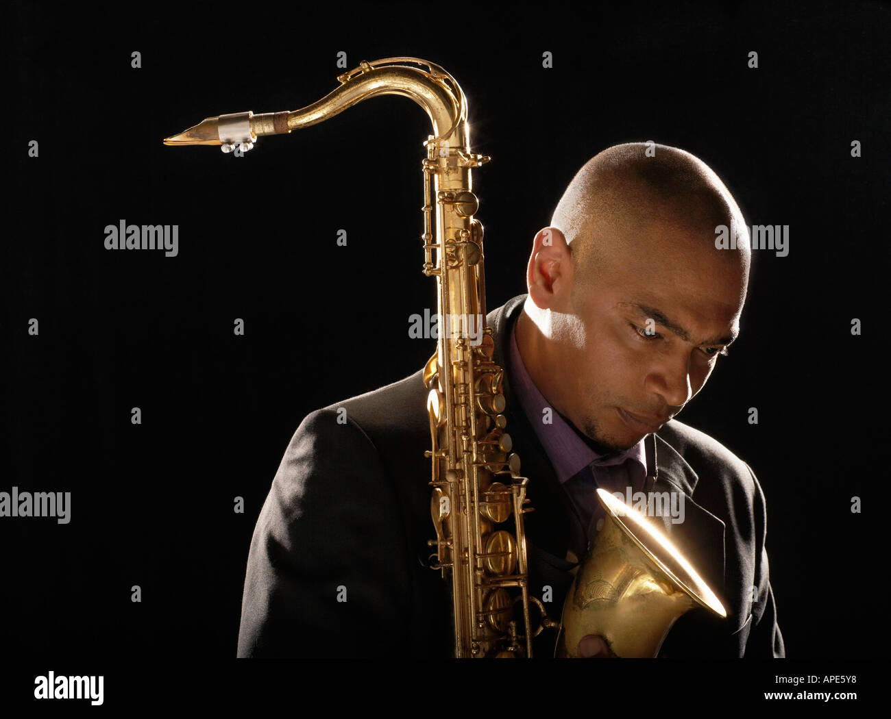 Pensive man holding saxophone, looking down, close-up Stock Photo - Alamy