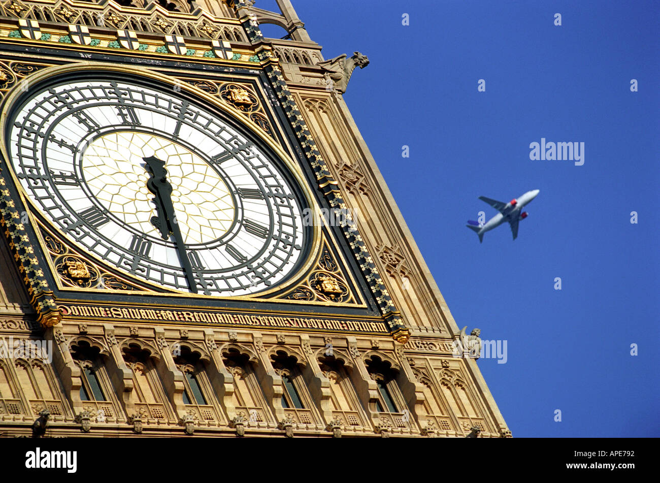 A airliner passes Big Ben in London England UK Stock Photo