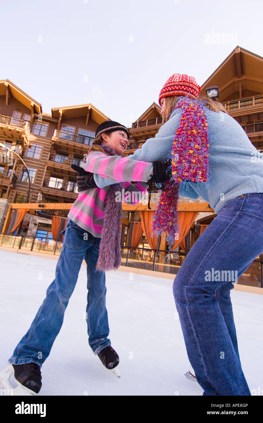 A mother and daughter dancing together on ice skates at Northstar ski resort near Lake Tahoe in California Stock Photo