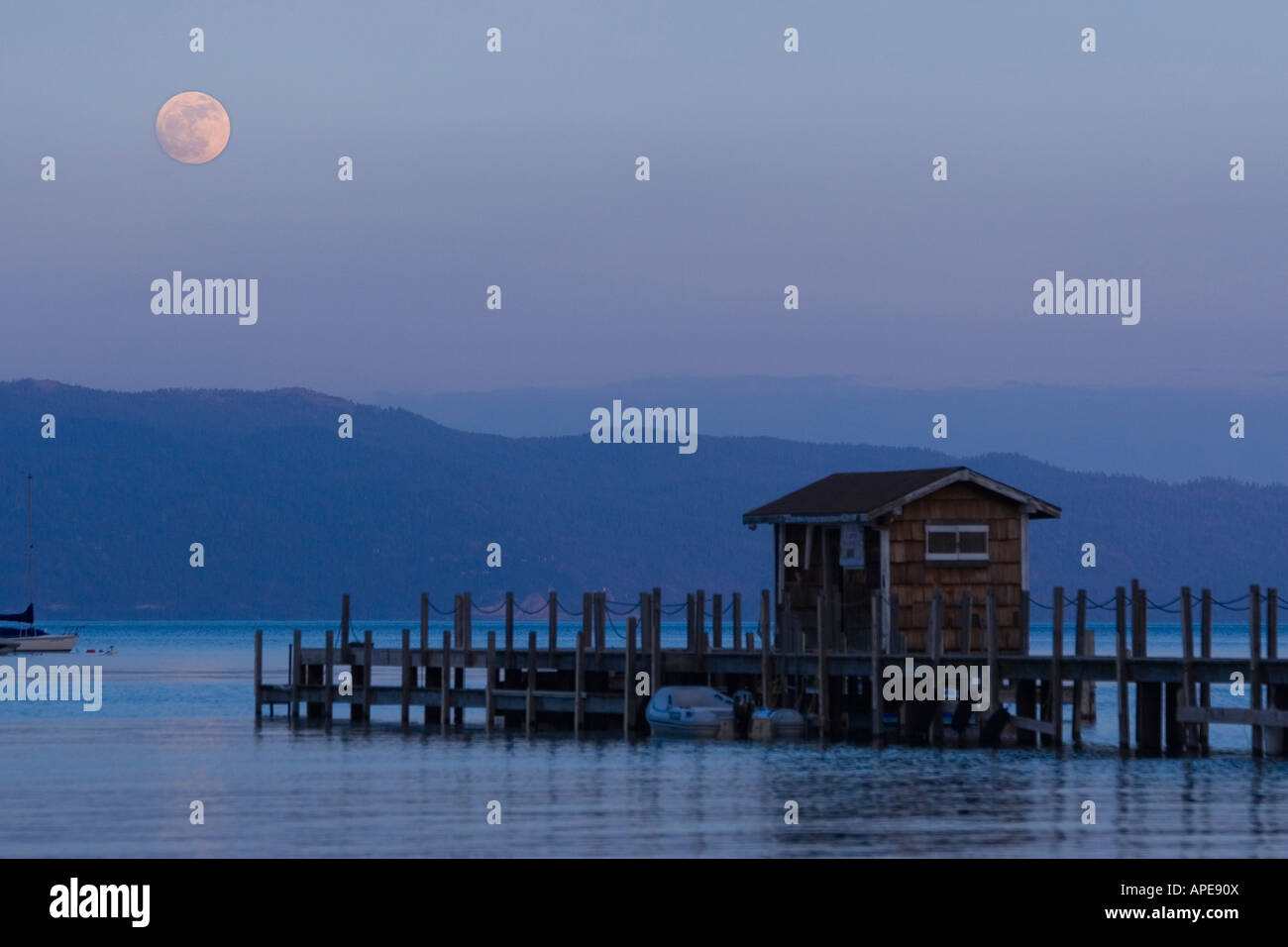 The full moon rising over Lake Tahoe, California and a pier Stock Photo