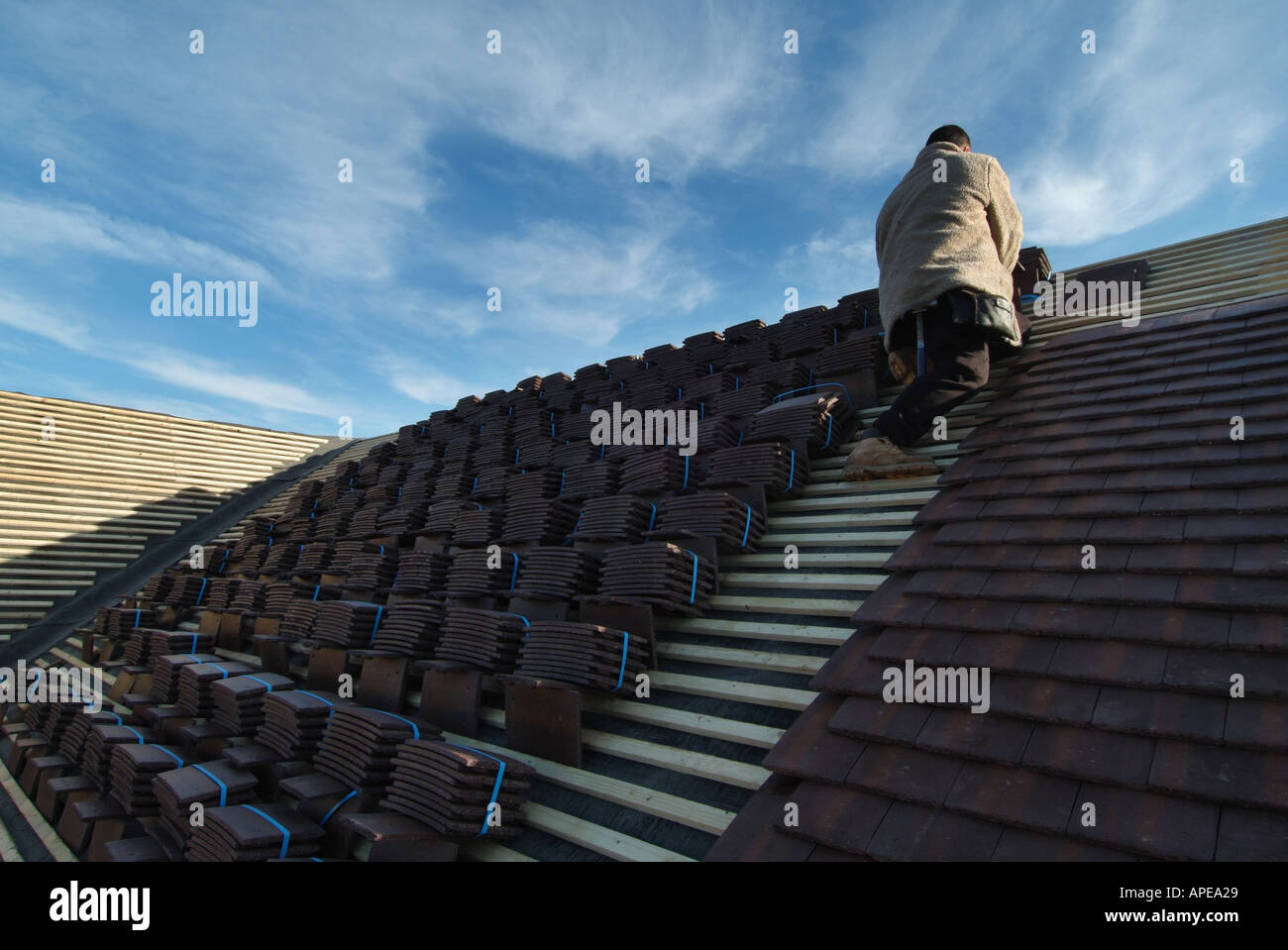 Detached house under construction roof tiling in progress on a cold winter day Stock Photo