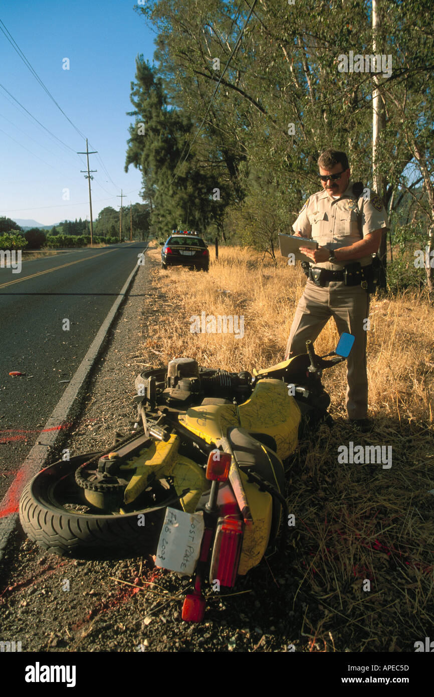 CHP Highway Patrol police officer writing accident report after a motorcyle crash on rural country road Napa Valley California Stock Photo