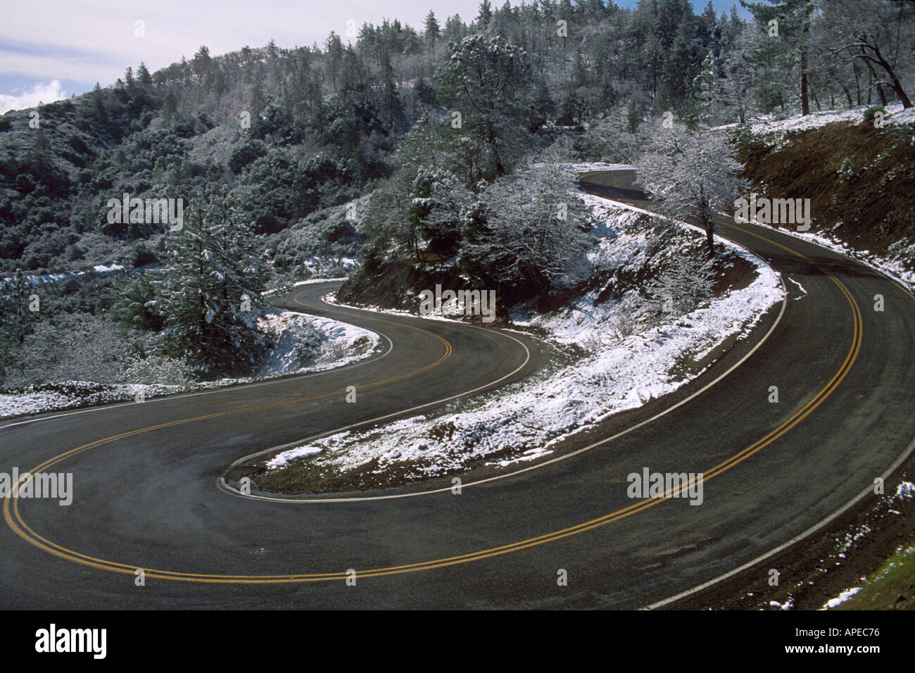 Snow along twisting curves of two lane mountain road Mount Hamilton Santa Clara County California Stock Photo
