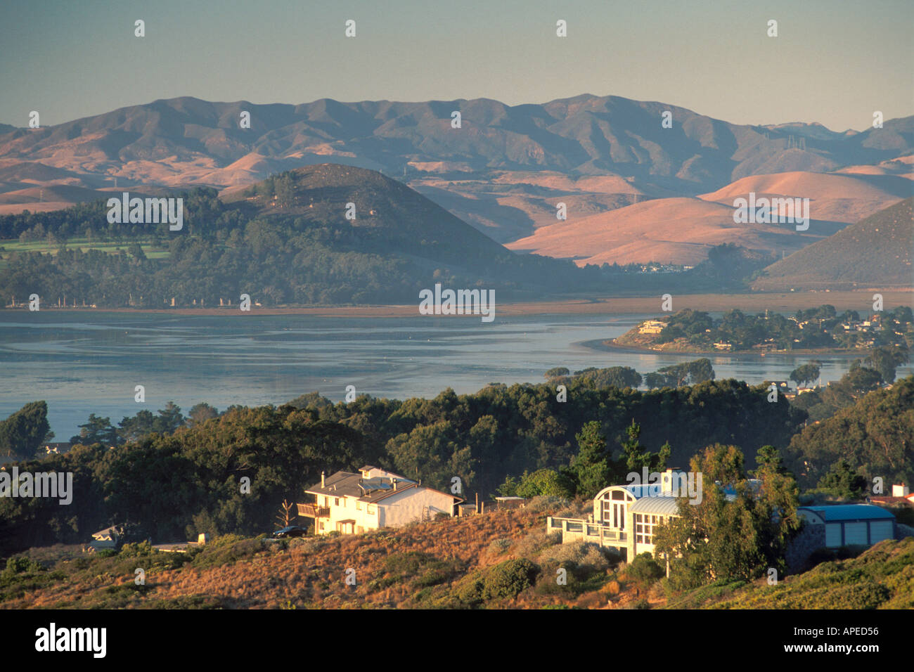 Luxury homes on hillside overlooking waters and the coastal hills above