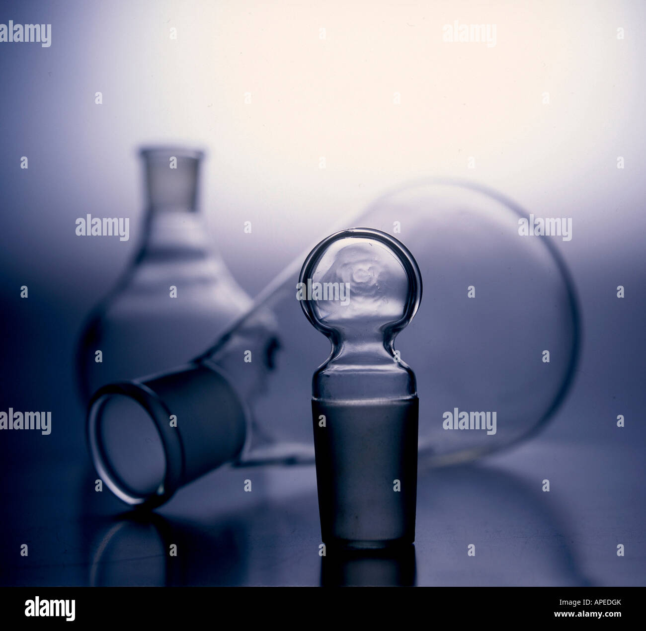 Silhouetted glass beakers and stopper on white background Stock Photo
