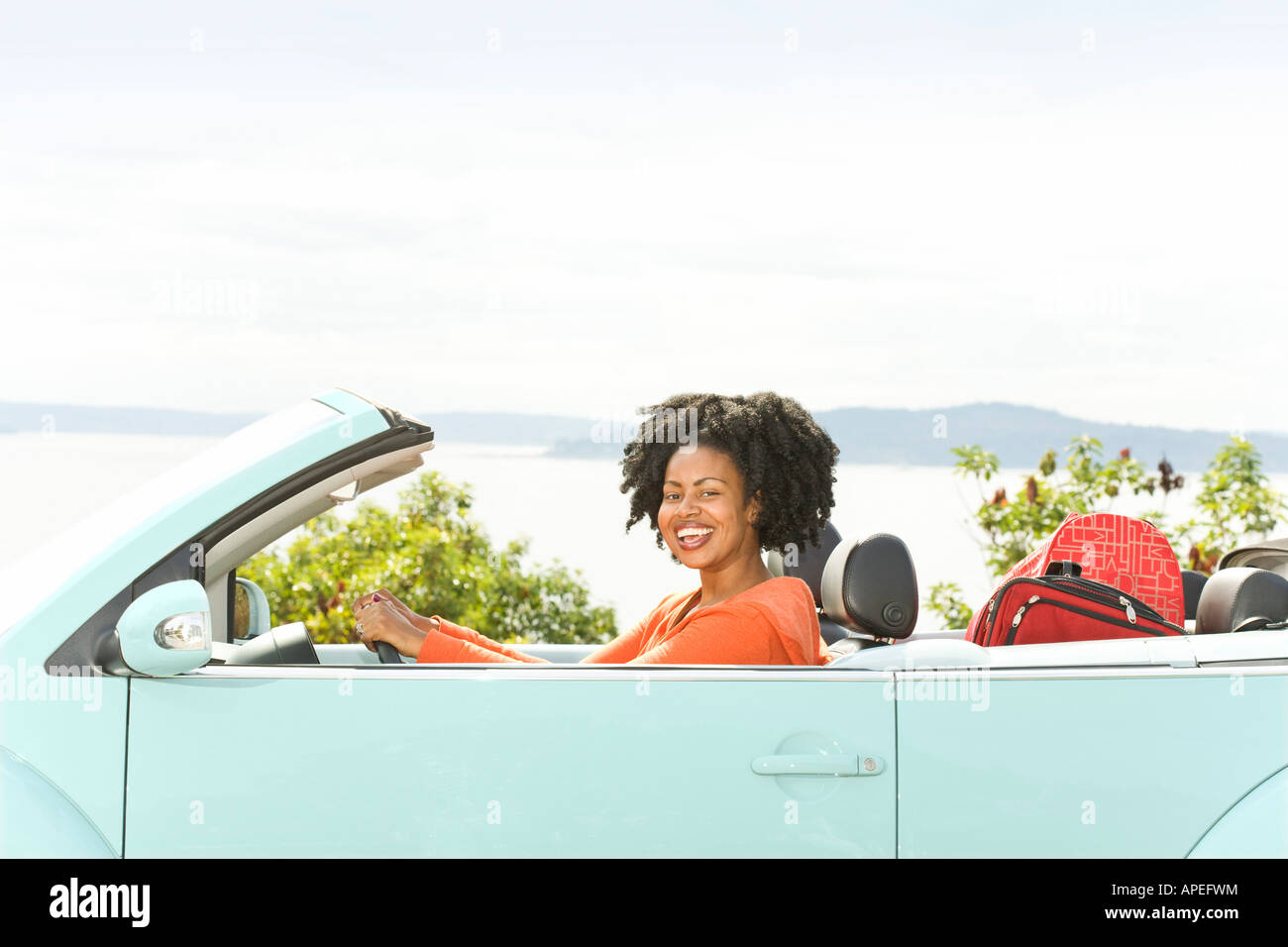 African woman driving convertible car Stock Photo