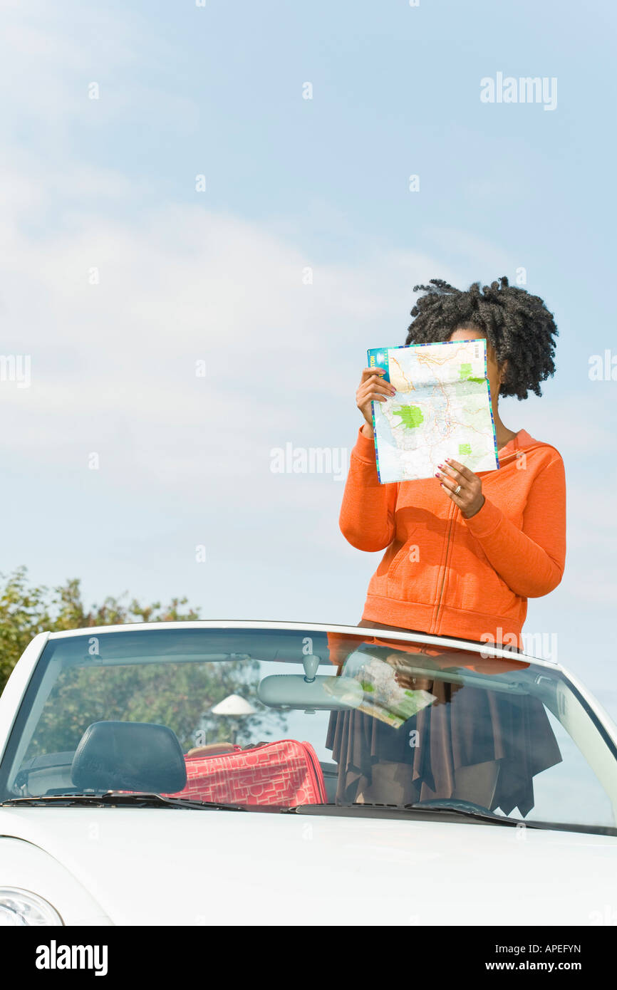 African woman reading map in convertible car Stock Photo