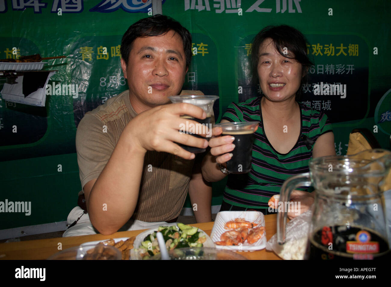A couple drink beer and eat snacks at the Tsingtao beer festival Qingdao Shandong China Stock Photo