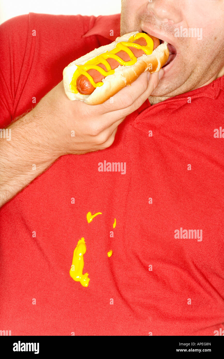 Man eating hotdog and spilling mustard on shirt Stock Photo Alamy