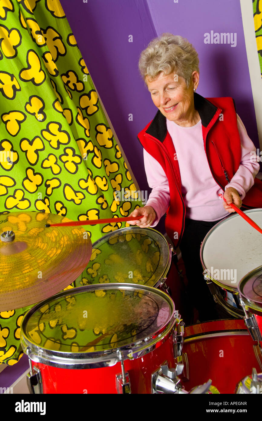 Senior woman playing drums Stock Photo