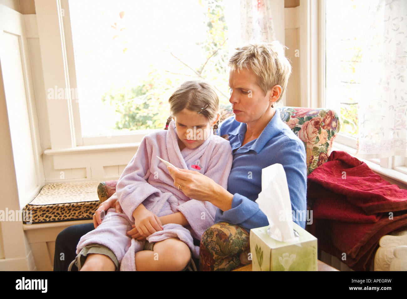 Mother taking sick daughter’s temperature Stock Photo