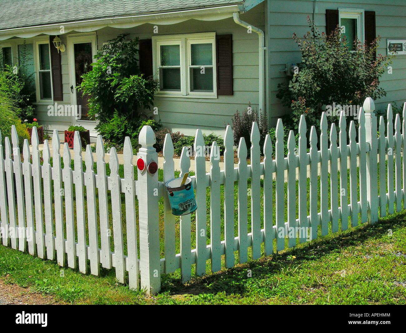 White picket fence and a can of paint Stock Photo Alamy