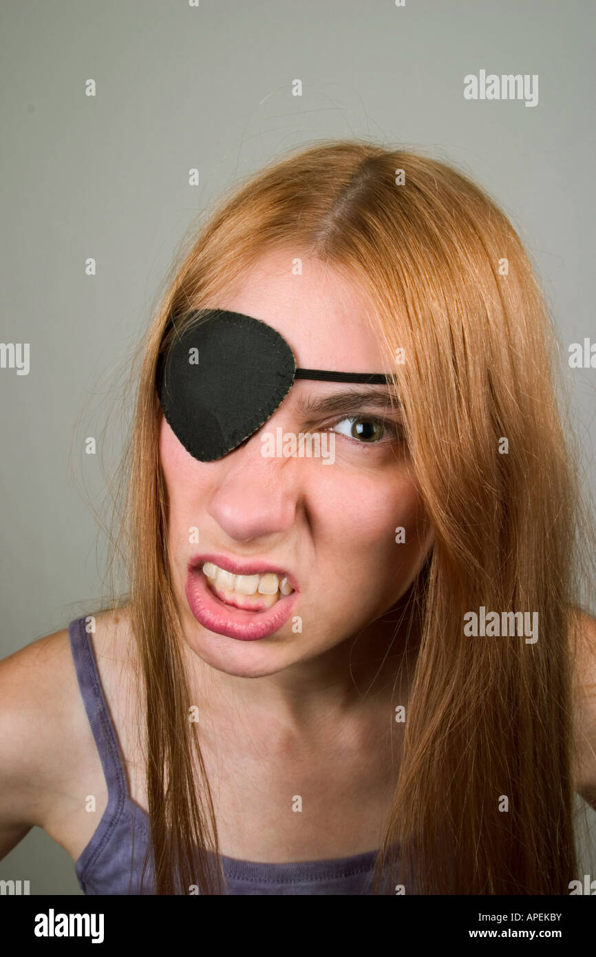 Young woman, with long red hair, wearing an eye patch and making faces