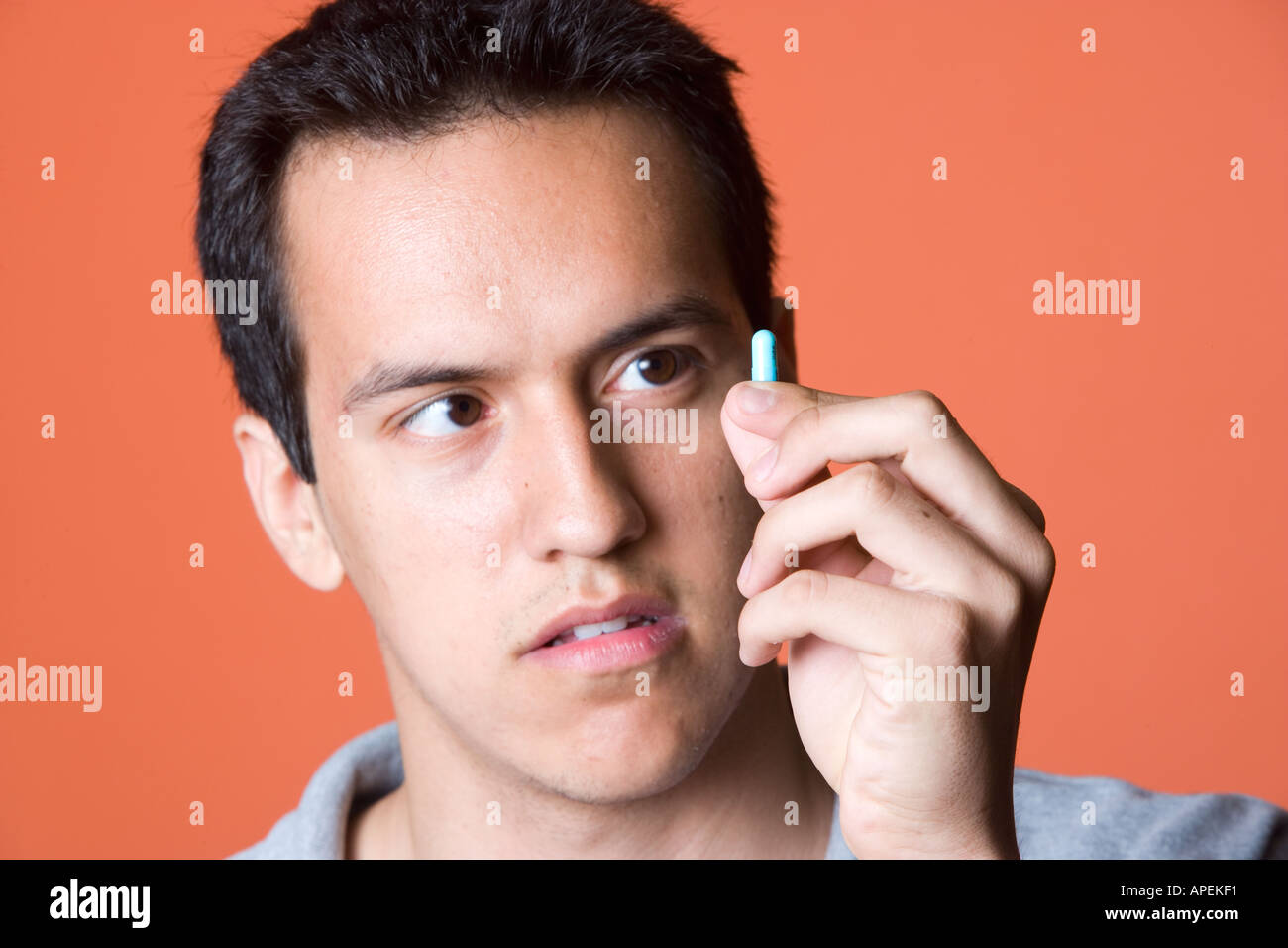 Portrait Latino man holding pharmaceutical capsule Stock Photo