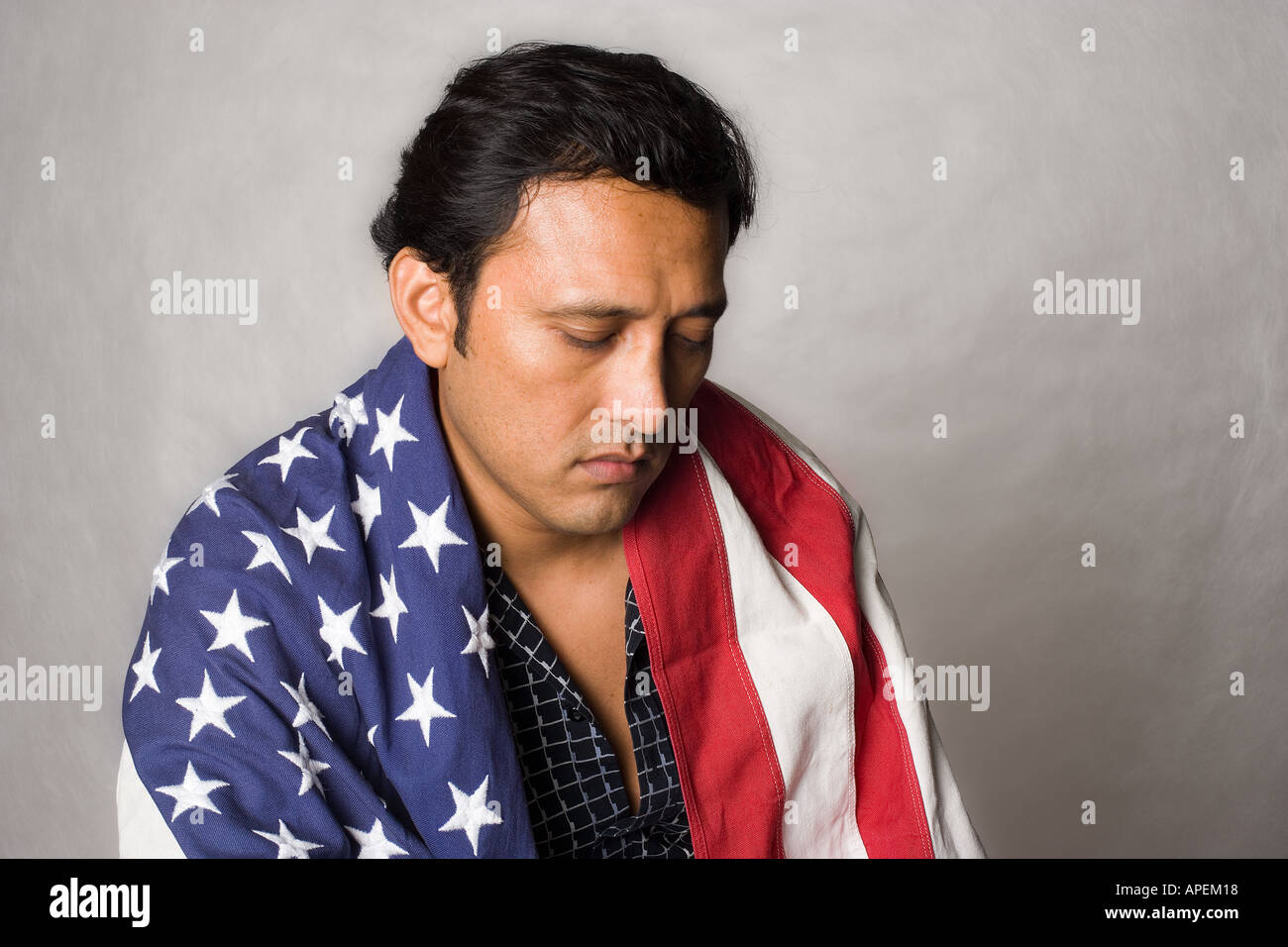 Portrait Latino man wrapped in American flag Stock Photo