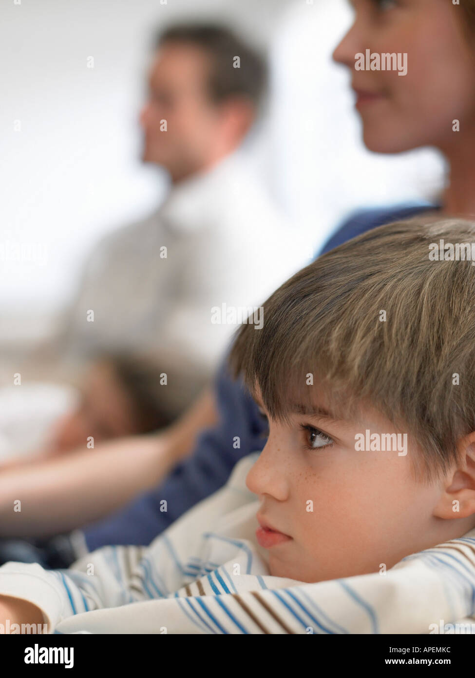 Boy (5-6) watching television with parents, (close-up) Stock Photo