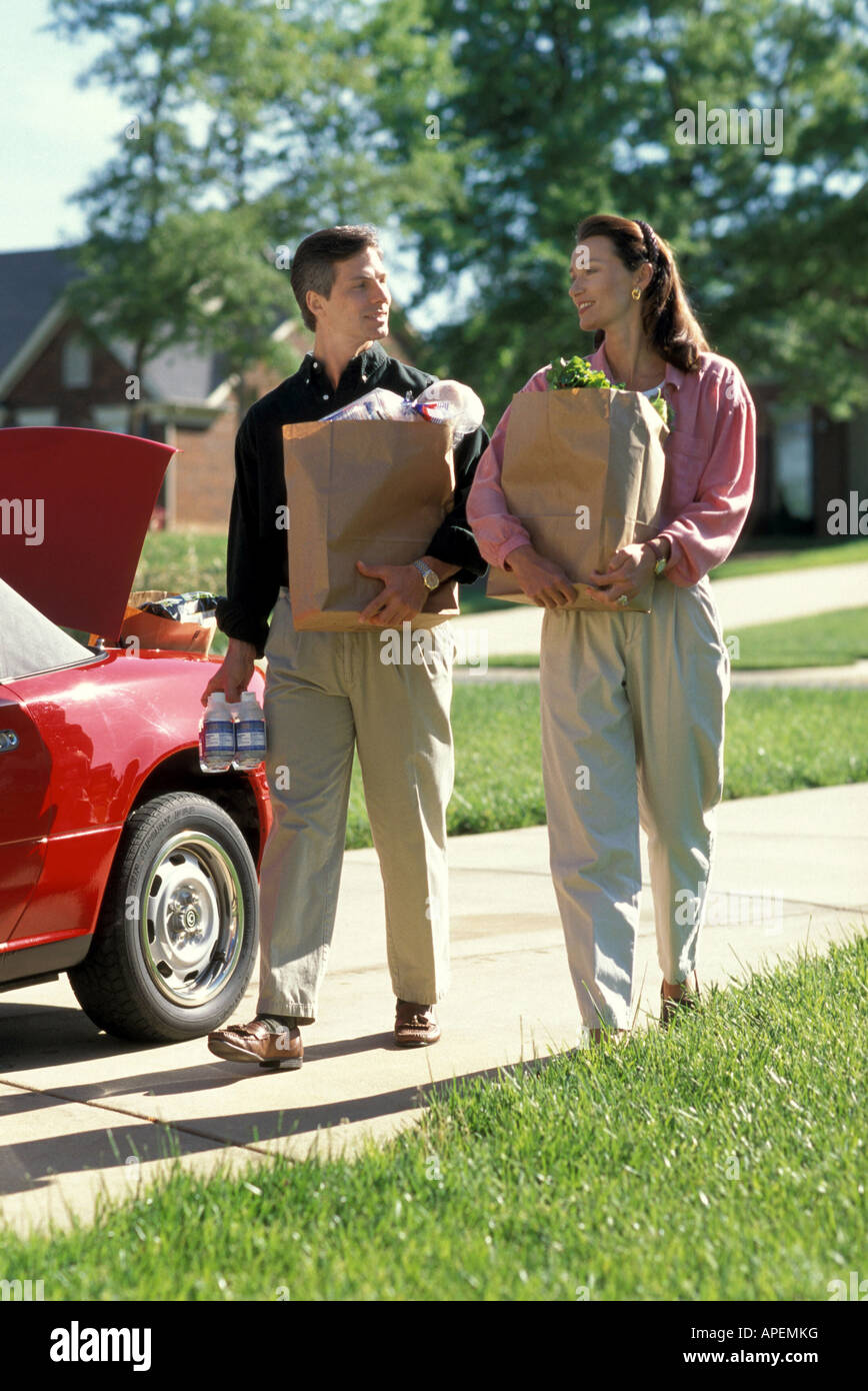 Couple carry groceries in from car Stock Photo Alamy